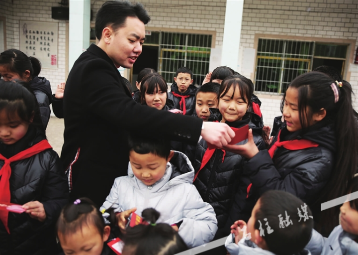 2月18日，谭贵华在万朝镇朱水小学给孩子们分发红包.jpg